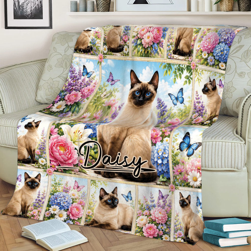 Floral Siamese cat blanket styled across a sofa, featuring blue-eyed cats, butterflies, and colorful flowers