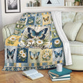 Butterfly floral throw blanket draped over a sofa with colorful daisies and garden artwork