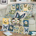 Decorative butterfly blanket displayed on a couch with daisy blossoms and blue floral panels