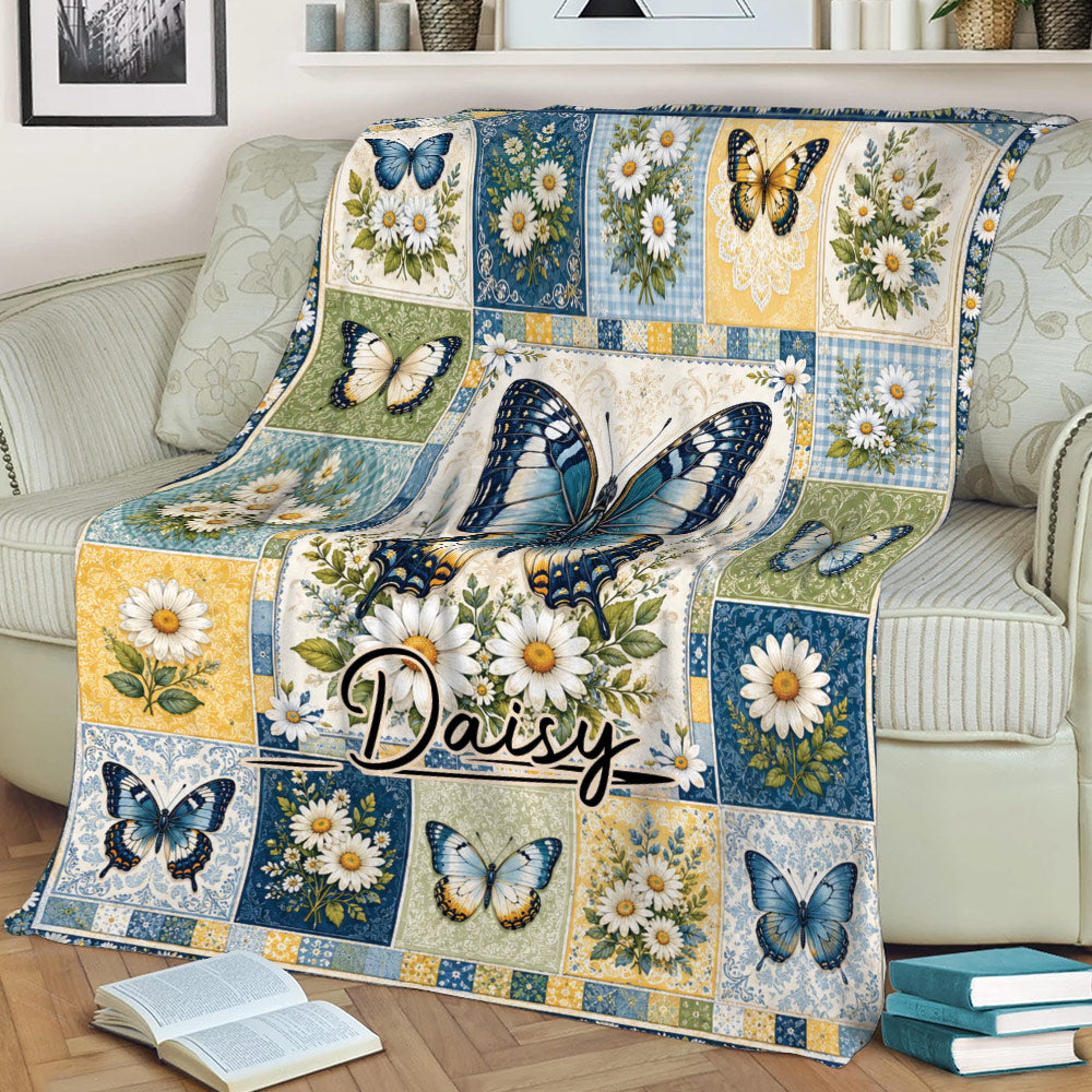 Decorative butterfly blanket displayed on a couch with daisy blossoms and blue floral panels