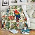 Parrot blanket draped over a sofa with vibrant tropical birds, flowers, and leafy botanical artwork