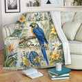 Tropical parrot throw blanket displayed on a sofa with colorful floral and leafy artwork