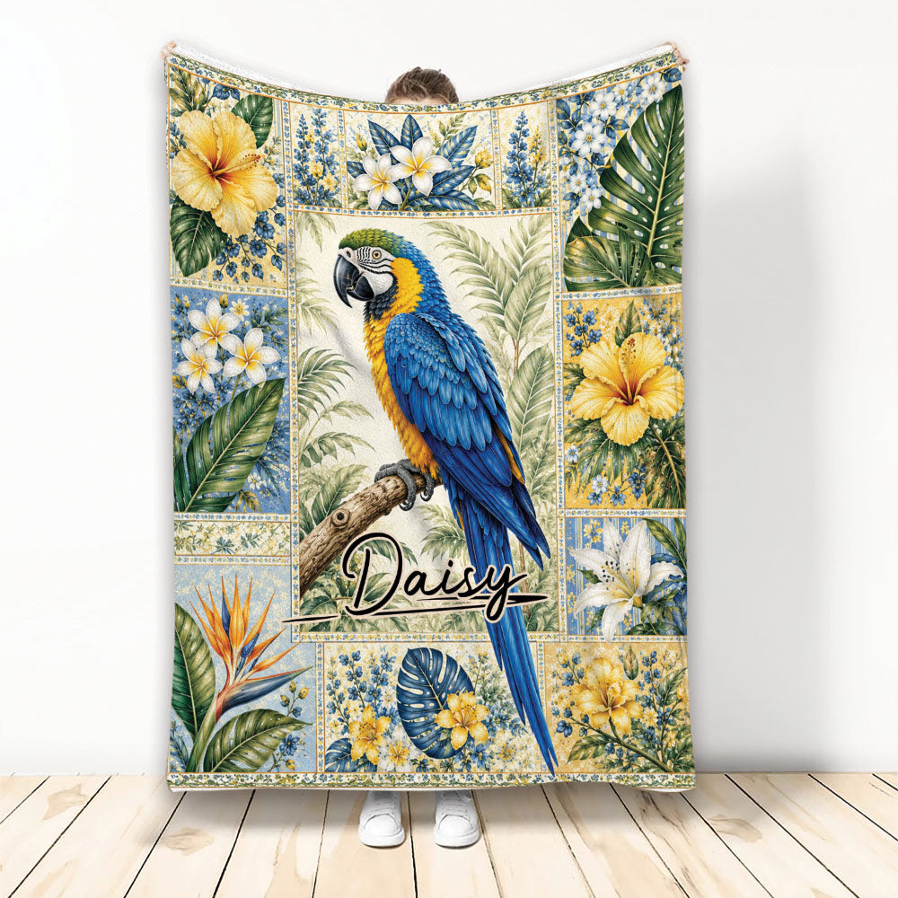 Tropical parrot blanket with blue and yellow bird artwork surrounded by hibiscus, plumeria, and lush leaves