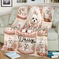 Maltese throw blanket styled across a sofa with white dogs, roses, pink cushions, and ornate vintage artwork