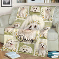 Maltese throw blanket spread across a couch with floral dog portraits and a green vintage-inspired design