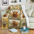 Highland cow throw blanket draped over a sofa with daisies, farmhouse florals, and rustic countryside artwork