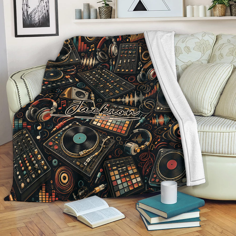 DJ throw blanket draped over a sofa with turntables, audio mixers, headphones, and music studio artwork