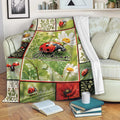 Ladybug throw blanket draped over a sofa with floral garden artwork and a cozy living room setting