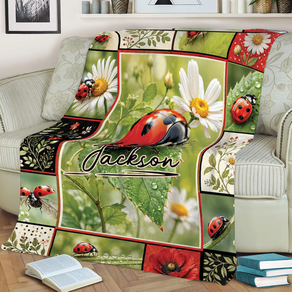 Close lifestyle view of a ladybug blanket on a couch featuring daisies, leaves, water droplets, and red flowers