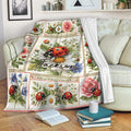 Ladybug floral throw blanket draped over a couch with botanical artwork and a cozy reading setting