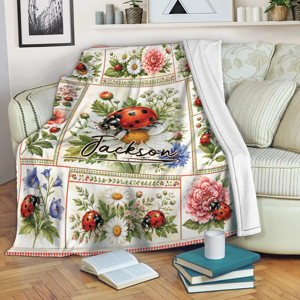 Ladybug floral throw blanket draped over a couch with botanical artwork and a cozy reading setting