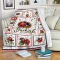 Ladybug throw blanket draped over a sofa with flowers, leafy accents, and framed insect illustrations
