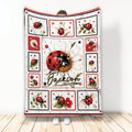 Ladybug throw blanket displayed upright with floral panels and red, black, and white garden artwork