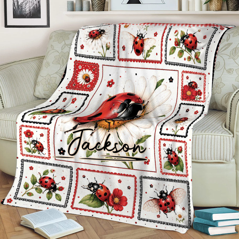 Floral ladybug throw blanket arranged on a couch, featuring detailed red and black ladybug artwork