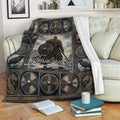 Viking blanket draped over a sofa with Norse warrior artwork, shields, ravens, and Nordic symbols