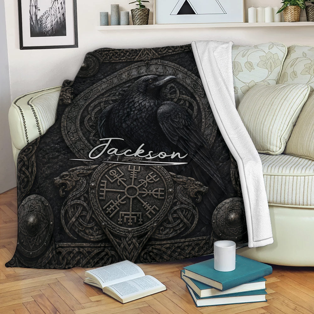 Viking throw blanket draped over a sofa with black raven artwork and Nordic ornamentation