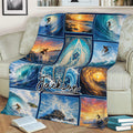 Surfing blanket displayed on a couch with surfers, ocean waves, sunset colors, and surfboard artwork
