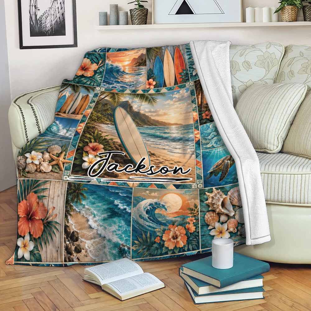 Surfing throw blanket draped over a sofa with tropical beach, surfboard, wave, and sea turtle artwork