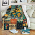 Bicycle throw blanket draped over a sofa, featuring vintage cycling artwork in teal, gold, and orange