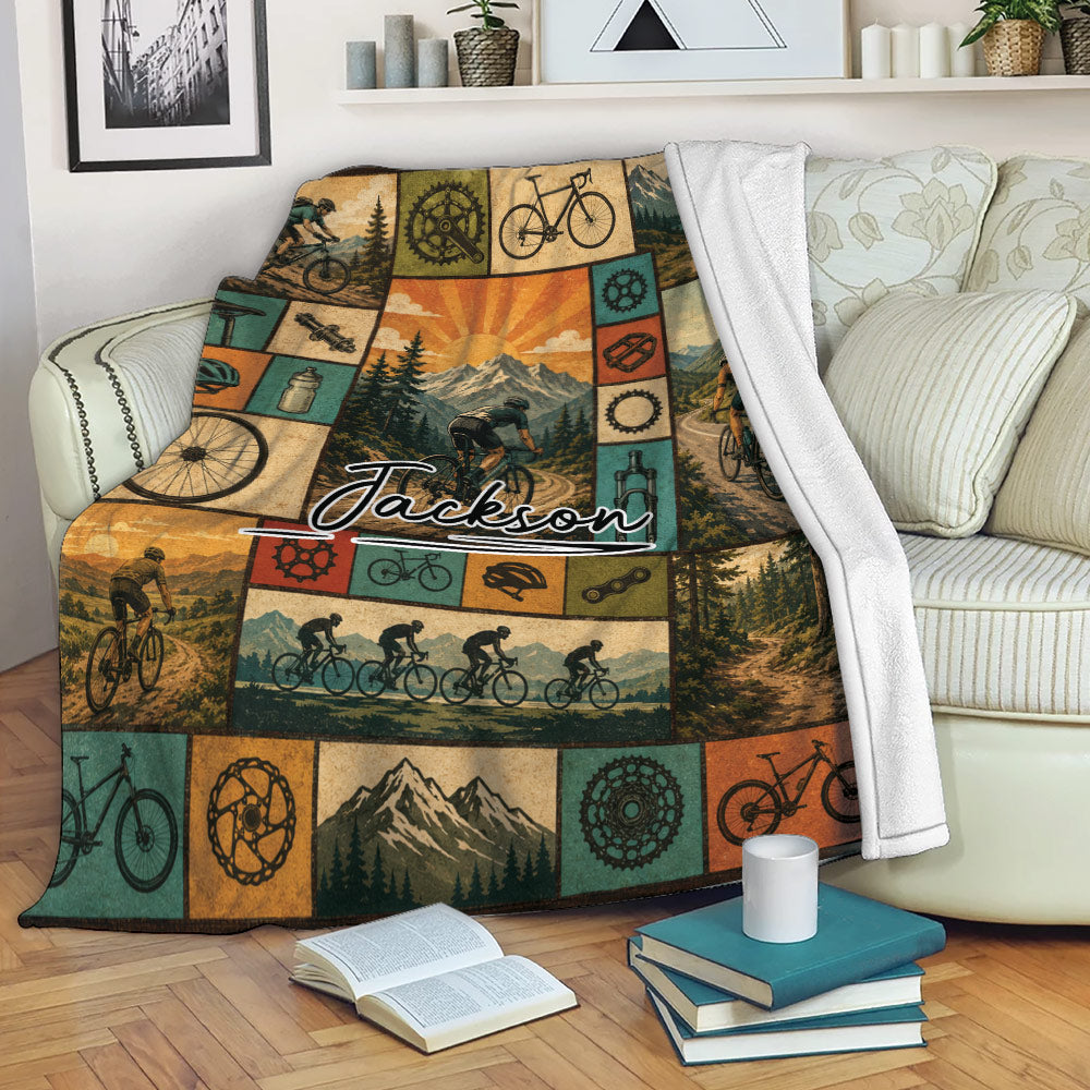 Custom bicycle throw blanket displayed on a sofa with mountain biking and cycling collage artwork