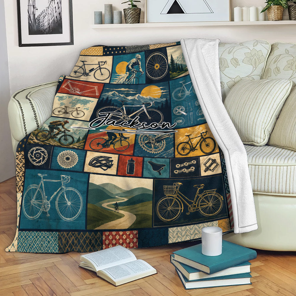 Bicycle throw blanket draped over a sofa with cycling collage artwork in blue, gold, and red