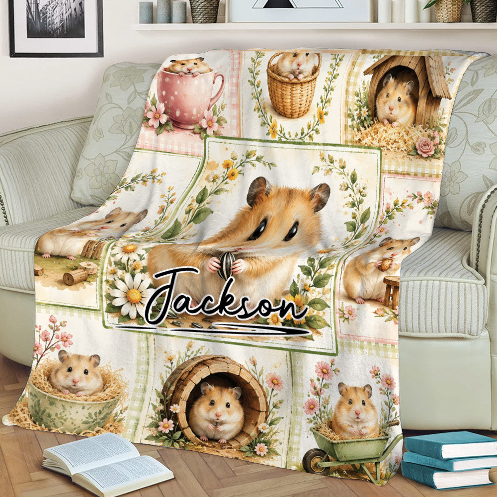 Cozy hamster throw blanket displayed on a sofa with floral borders and playful illustrated hamsters