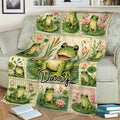 Close view of frog throw blanket on a sofa featuring a large smiling frog and colorful floral pond scenes