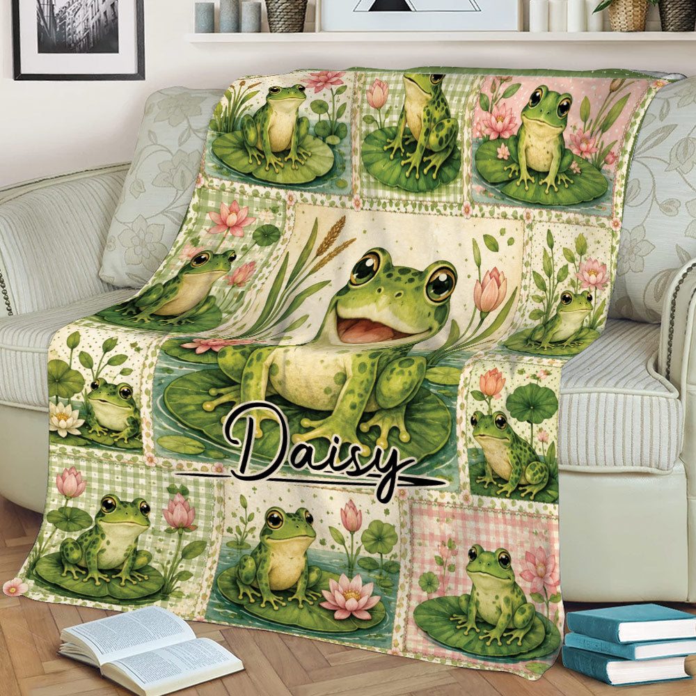 Close view of frog throw blanket on a sofa featuring a large smiling frog and colorful floral pond scenes