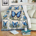 Blue butterfly and floral throw blanket draped over a sofa in a cozy living room