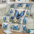 Close lifestyle view of a blue butterfly floral blanket arranged over a sofa