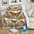 Butterfly throw blanket draped over a sofa with orange butterflies and floral garden artwork