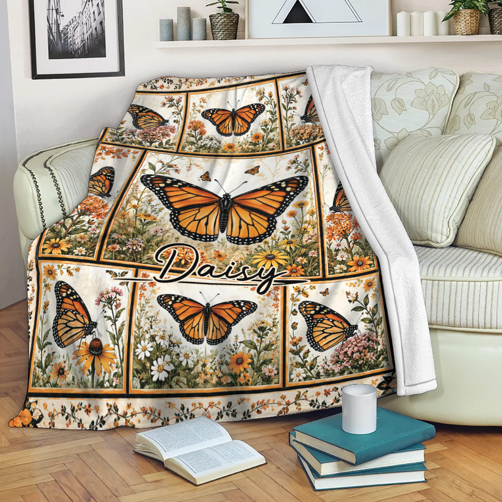 Butterfly throw blanket draped over a sofa with orange butterflies and floral garden artwork