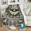 Butterfly throw blanket draped over a sofa with botanical flowers, moon motifs, and a cozy reading setting