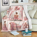 Pink ballerina throw blanket draped over a sofa with pointe shoes, roses, tutus, and ballet artwork