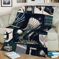 Badminton blanket spread across a sofa featuring shuttlecocks, crossed rackets, and court graphics