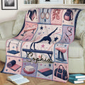 Gymnastics throw blanket displayed on a couch with gymnast silhouette, beam, rings, vault, and rhythmic ribbon artwork