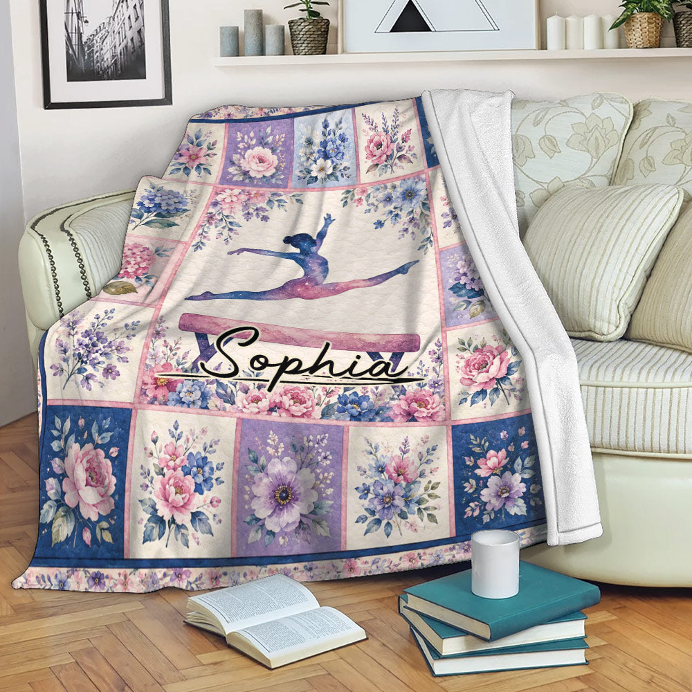 Floral gymnastics blanket displayed on a couch with a central gymnast design