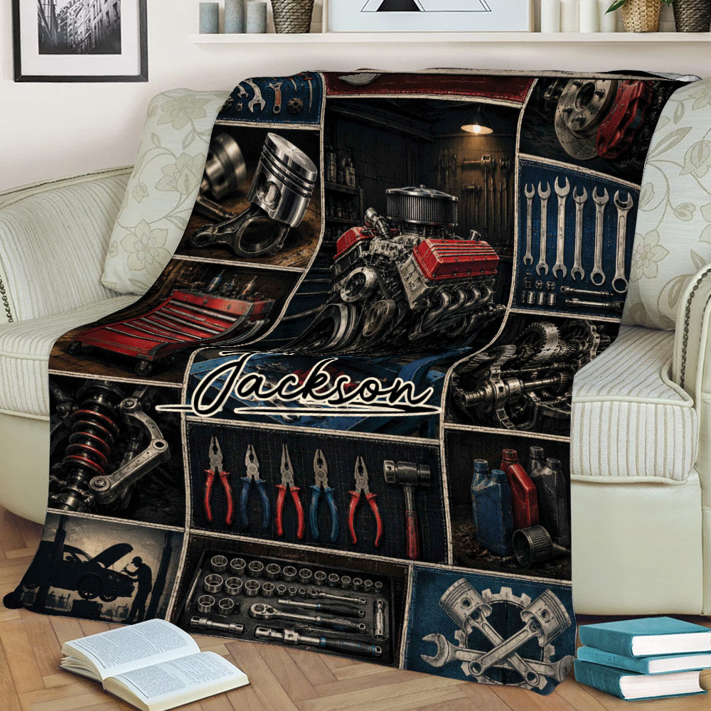 Close lifestyle view of a mechanic throw blanket featuring an engine, hand tools, pistons, and garage imagery