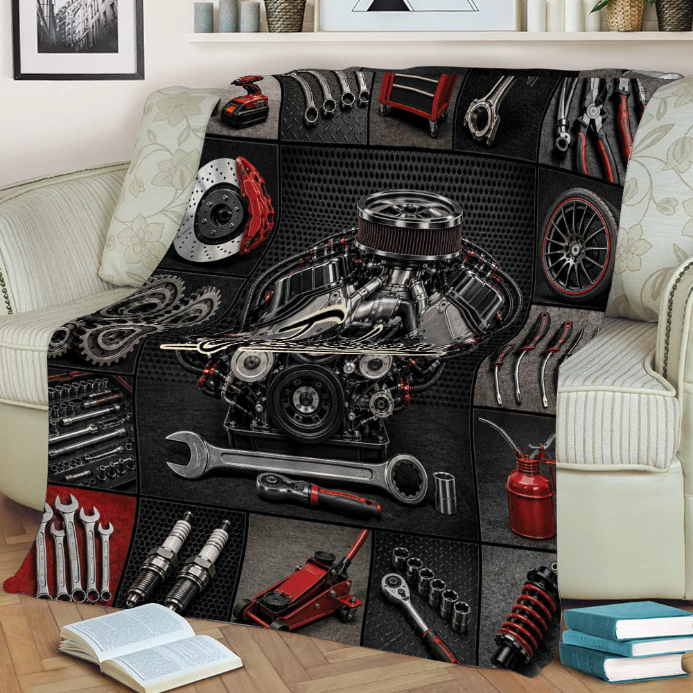 Garage-themed mechanic blanket draped across a sofa with engine, wrench, gear, and automotive tool artwork