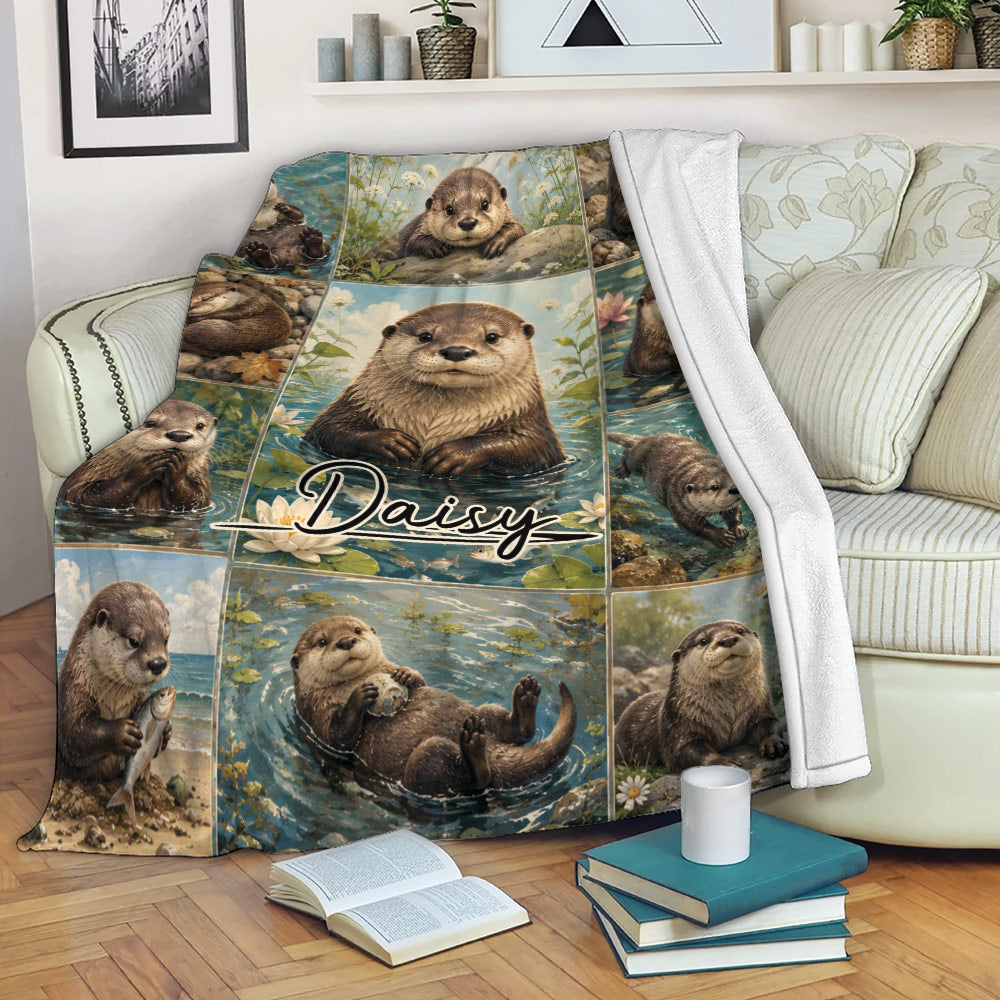 Otter throw blanket draped over a sofa, featuring illustrated river otters, ponds, flowers, and woodland colors