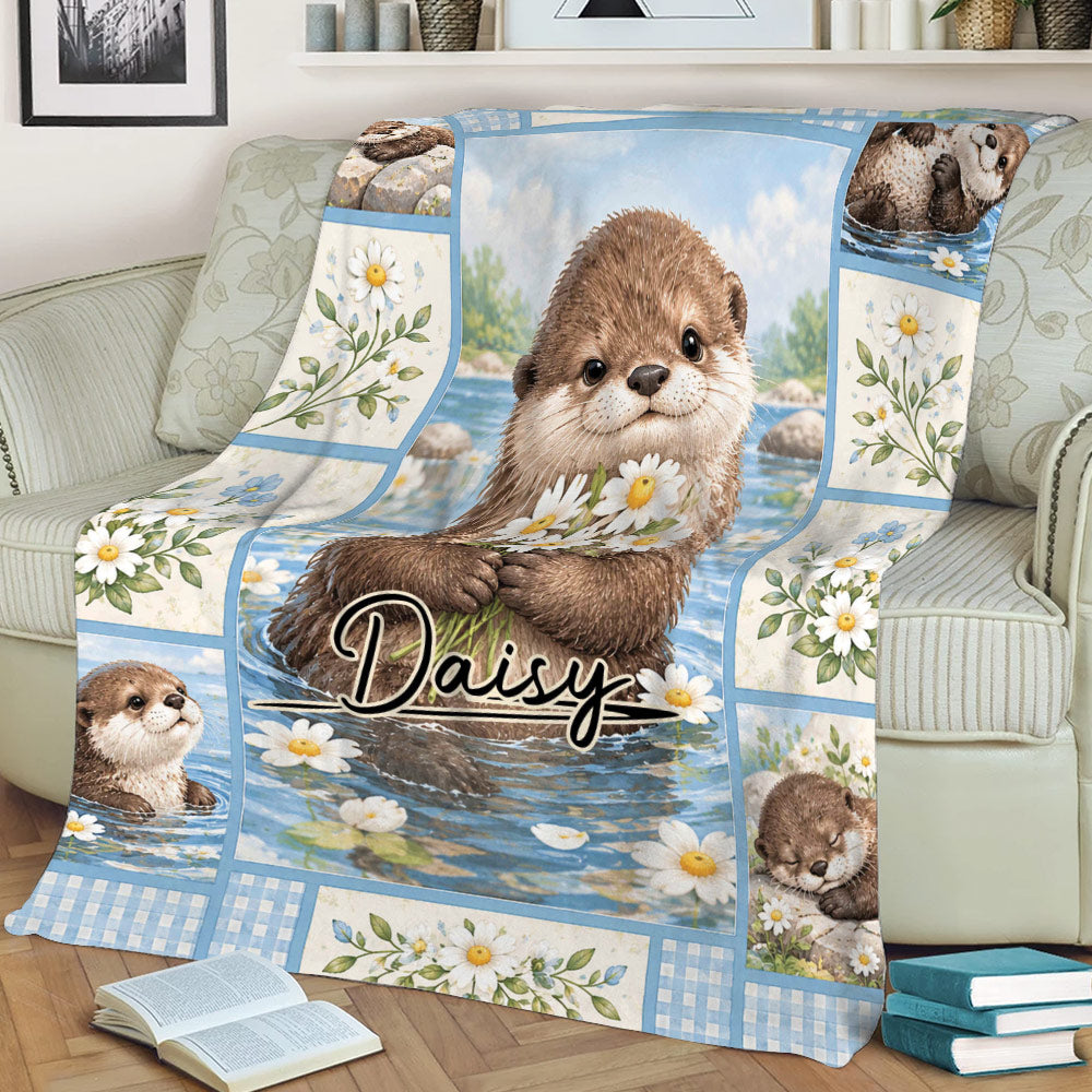 Close view of an otter throw blanket with water, daisies, blue borders, and woodland-inspired artwork