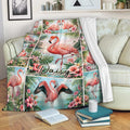 Flamingo throw blanket draped over a sofa with tropical flowers and coastal artwork