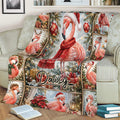 Christmas flamingo throw blanket displayed on a couch with snowy scenery, poinsettias, presents, and ornaments