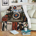 Archery throw blanket displayed on a sofa with colorful targets, bows, arrows, quivers, and mountain artwork