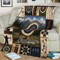 Archery throw blanket draped over a sofa, showing target artwork, bows, arrows, and scenic mountains