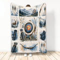 Archery blanket held up showing watercolor bows, arrows, target, mountain landscape, and deer artwork