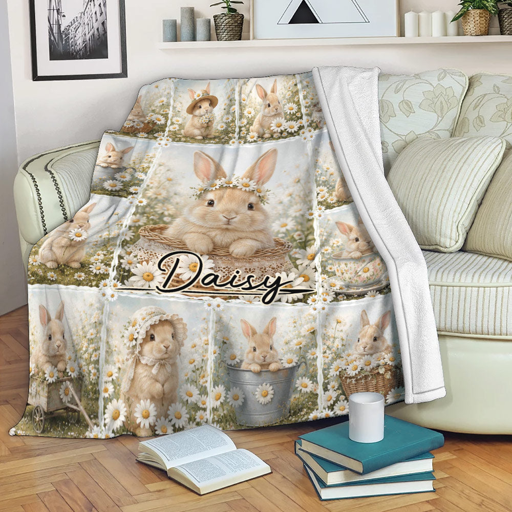 Rabbit blanket draped over a sofa, featuring soft bunnies, daisies, baskets, and garden imagery
