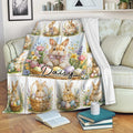Easter rabbit throw blanket displayed on a sofa with floral bunny and colorful egg artwork