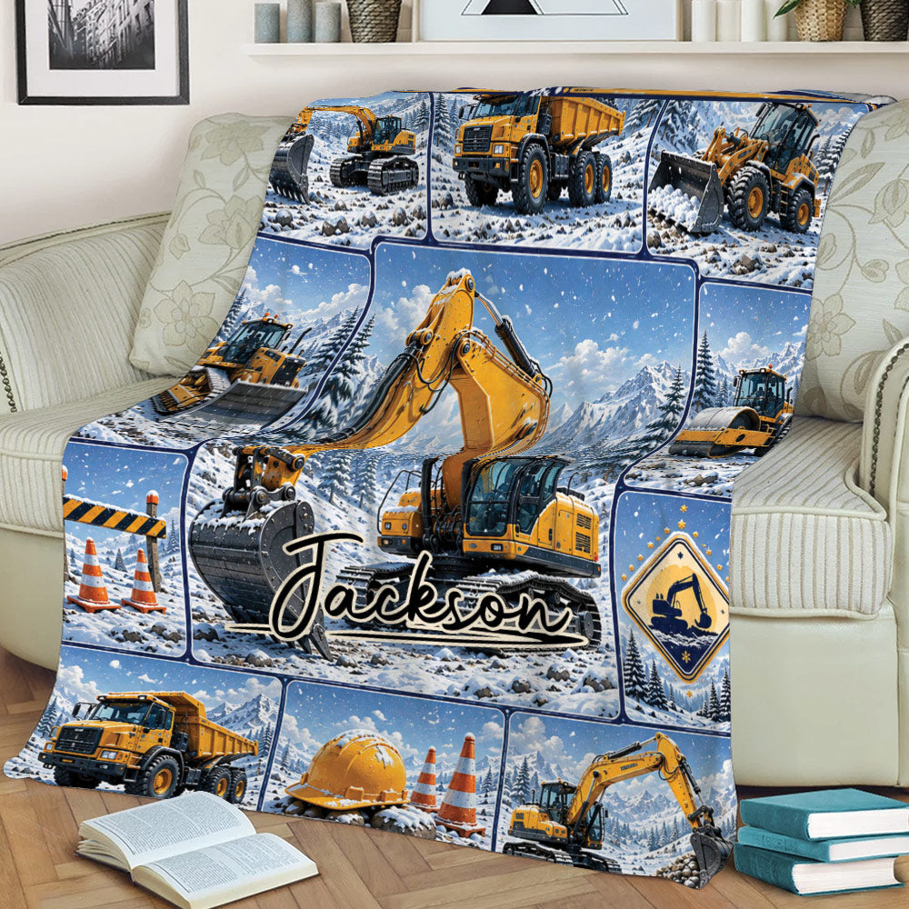 Excavator blanket styled on a couch with heavy equipment and winter mountain artwork