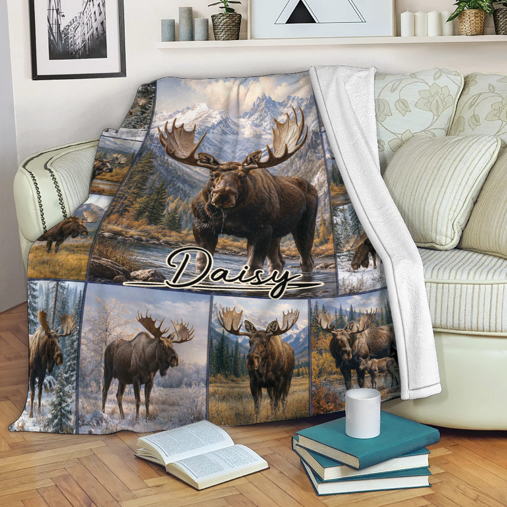 Moose blanket draped over a sofa with mountain scenery, forest, and wildlife artwork